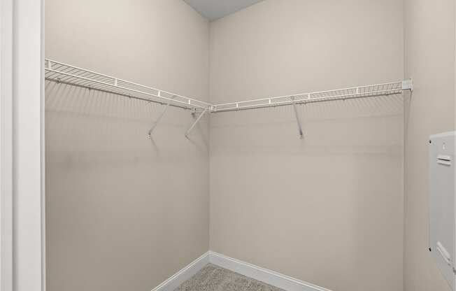 A white closet with a white shelf and a white door.