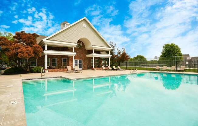 A house with a pool in front of it.