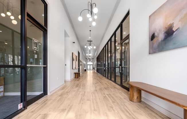 a long hallway with glass doors and a bench