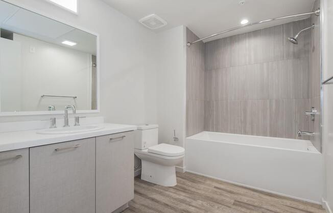 A white bathroom with a toilet, sink, and bathtub.