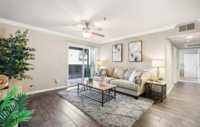 a living room with a couch and a ceiling fan