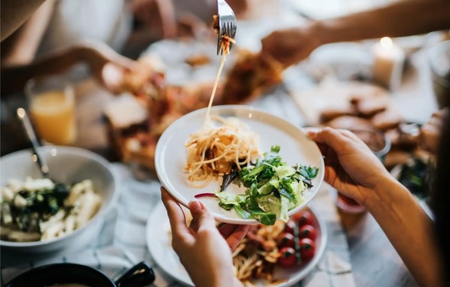 a group of people sitting around a table eating food with
