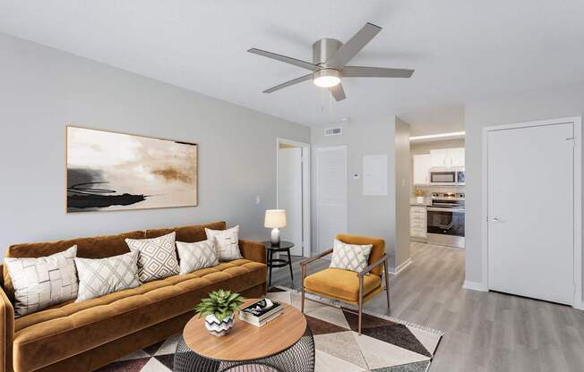 A living room with a brown couch, a coffee table, and a painting on the wall.