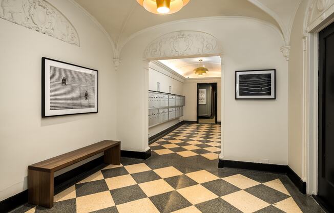 a hallway in a building with a checkered floor and benches