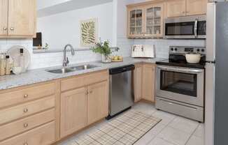 a kitchen with wooden cabinets and stainless steel appliances