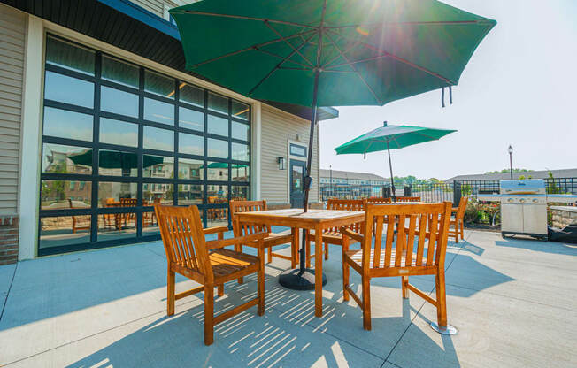 a patio with tables and umbrellas outside of a building