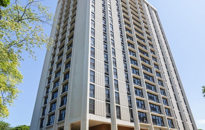 a tall building with many windows and a sidewalk in front of it