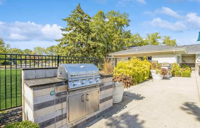 the backyard has a grill and a patio with a house