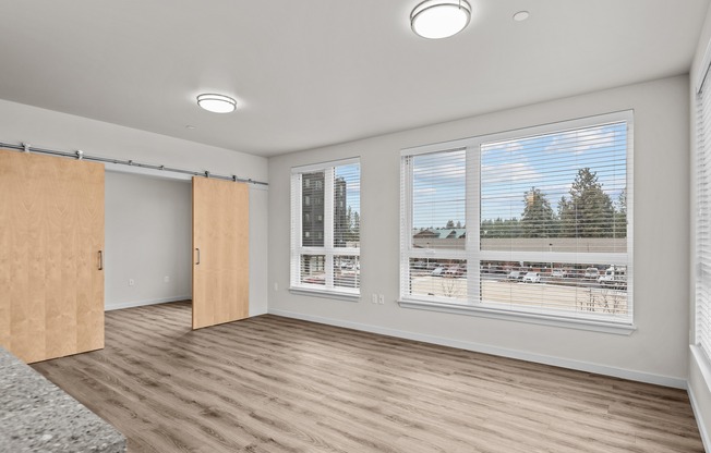 spacious living area with large windows and sliding barn doors into the bedroom