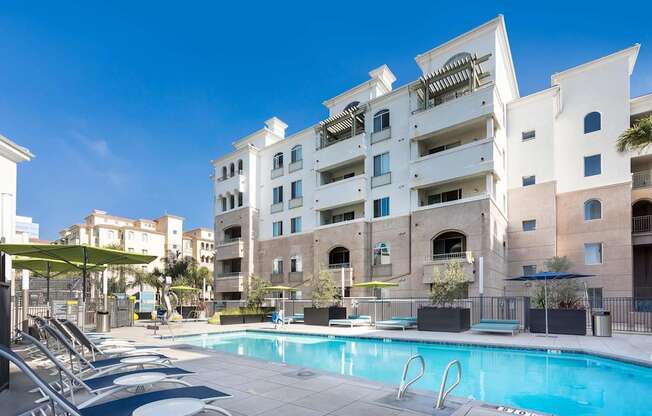 A large white building with a pool in front. at La Jolla Crossroads Apartments, San Diego