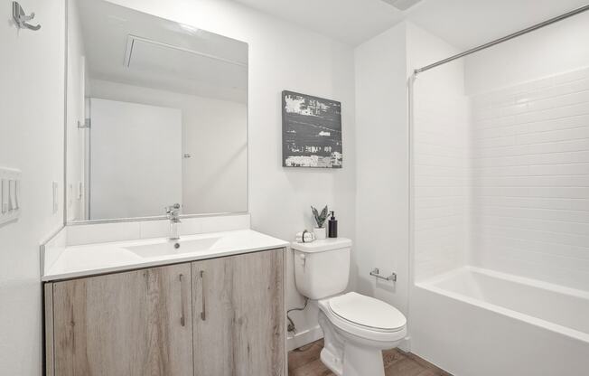 a bathroom with a toilet sink and shower and a mirror