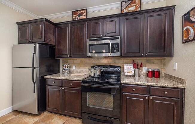A kitchen with dark brown cabinets and stainless steel appliances.