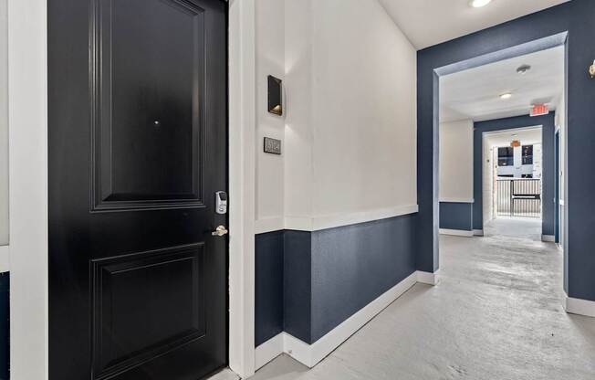 A black door with a silver handle is on the left and a white door with a silver handle is on the right.