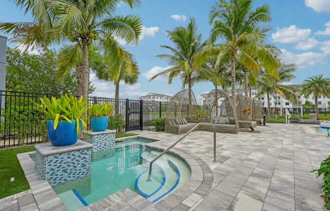 a swimming pool with palm trees and a black fence