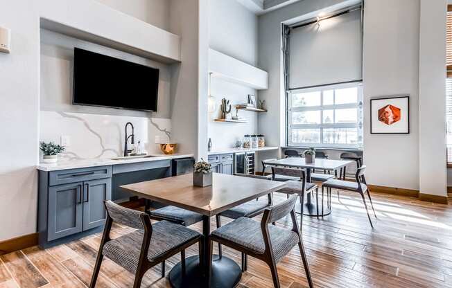 a dining room with a table and chairs and a kitchen with a tv at The links at Plum Creek Apartments, Castlerock Colorado