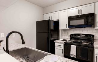 a kitchen with black appliances and granite counter tops