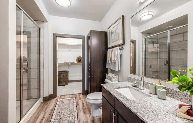 a bathroom with a shower and a sink and a toilet