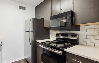 an empty kitchen with a stove and a refrigerator