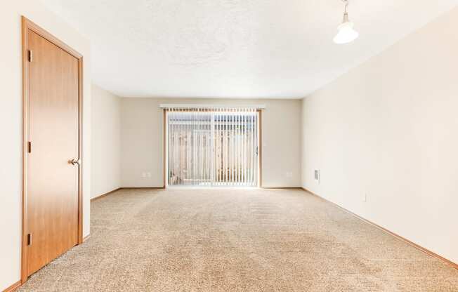 a bedroom with a door and a carpeted floor