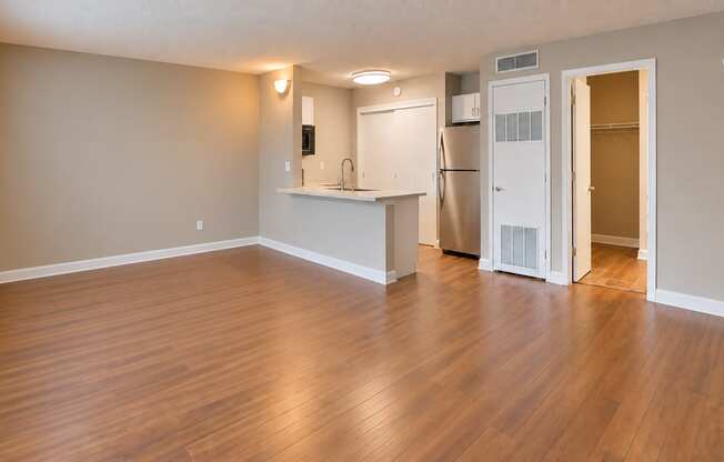 Unfurnished studio showing the open living area, breakfast bar and kitchen at Waterchase Apartments in Largo, FL.