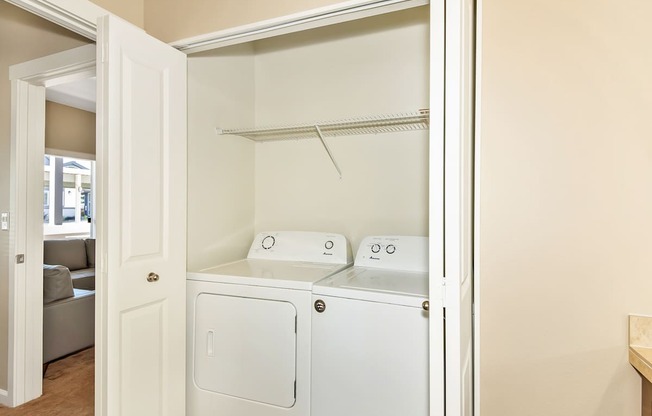 A white laundry room with a washer and dryer at The Landing Apartments and Townhomes, Oregon, 97045