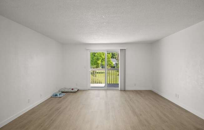 an empty living room with a door leading to a yard