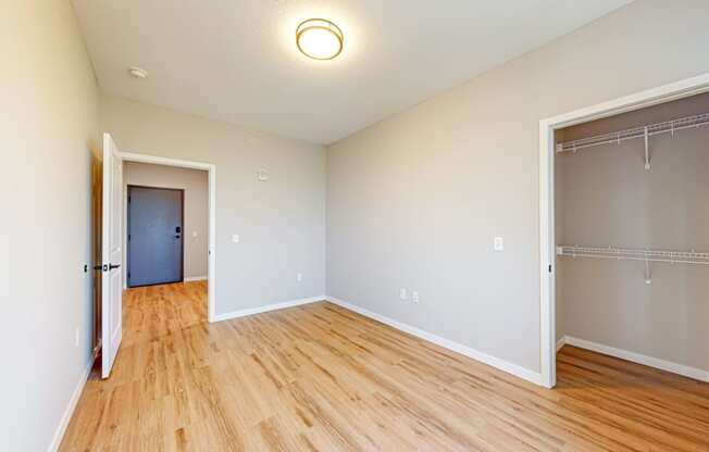 a bedroom with a door to a closet and a hard wood floor