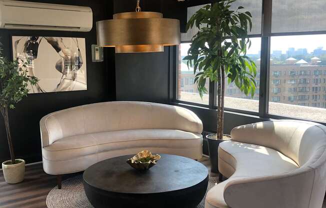 A black hat with a gold emblem sits on a white chair.
