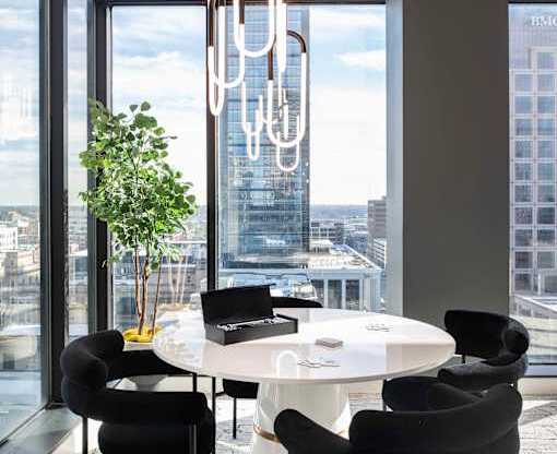 a round white table with black chairs in a room with floor to ceiling windows  at 220 Meridian, Indianapolis, IN, 46204