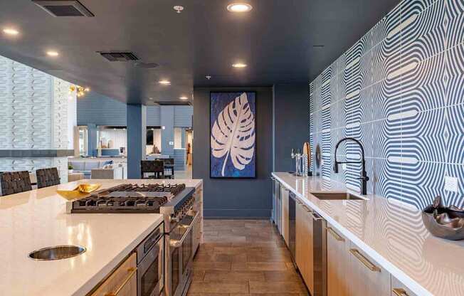a large kitchen with white countertops and a large painting on the wall