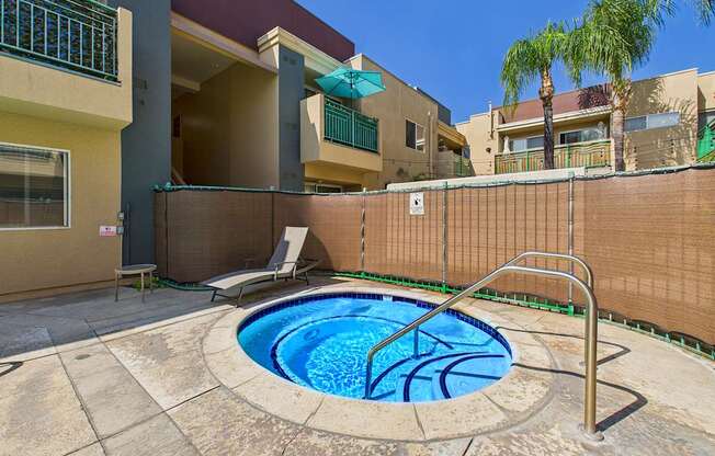 A small pool with a metal ladder sits in the middle of a patio.