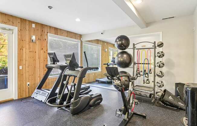 A fitness center with a treadmill, exercise bike, and weights.