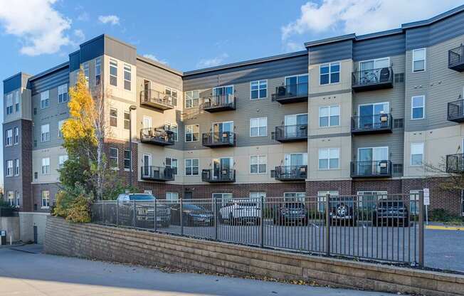 Apartment building with a yellow tree in front.