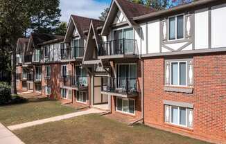 A row of red brick houses with white trim and balconies.