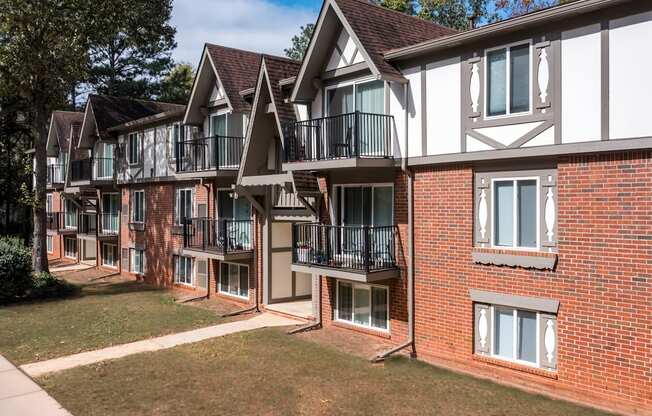 A row of red brick houses with white trim and balconies.