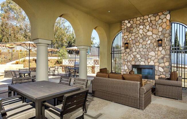 BBQ area with a fire pit, tables, couches outside