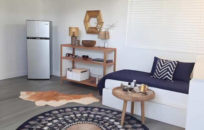 A living room with a couch, a rug, and a ceiling fan.
