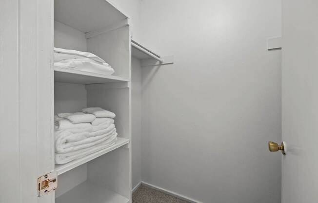 A white cabinet with towels on shelves.