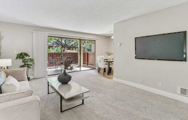 a living room with a tv and a sliding glass door at Summerwood Apartments, Santa Clara, 95050