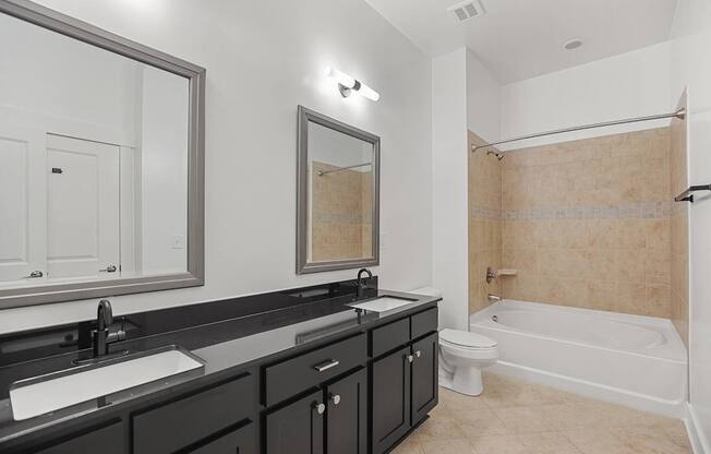A bathroom with a white tub, sink, and mirror.