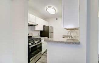 a kitchen with white cabinets and stainless steel appliances at Avondale Overlook, Hyattsville, Maryland