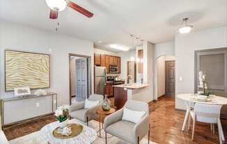 a living room and kitchen with a dining table and chairs