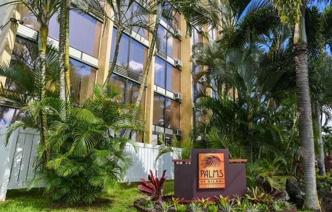 a sign in front of Palms of Kilani with palm trees at Palms of Kilani Apartments, Wahiawa, HI 96786