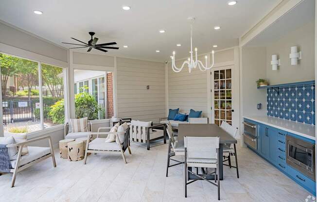 A modern kitchen and dining area with a ceiling fan and chandelier.