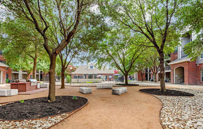 A tree-lined walkway leads to a building.