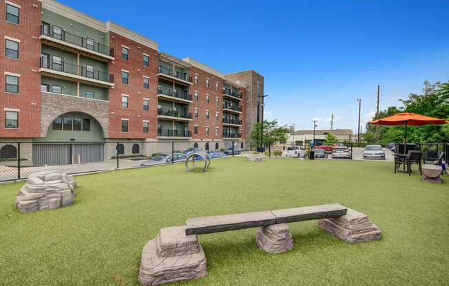 Dog park with a stone bench in front of The Vue apartments in Indy