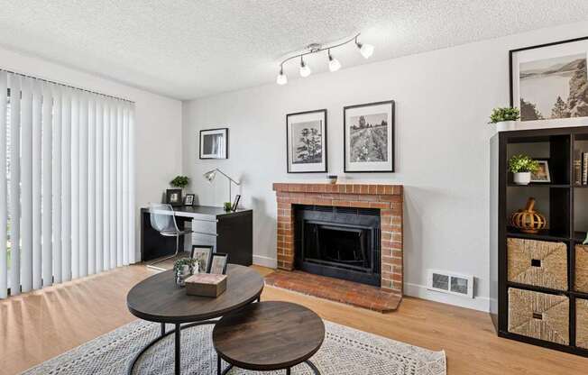 A living room with a fireplace and a table with a plant on it.