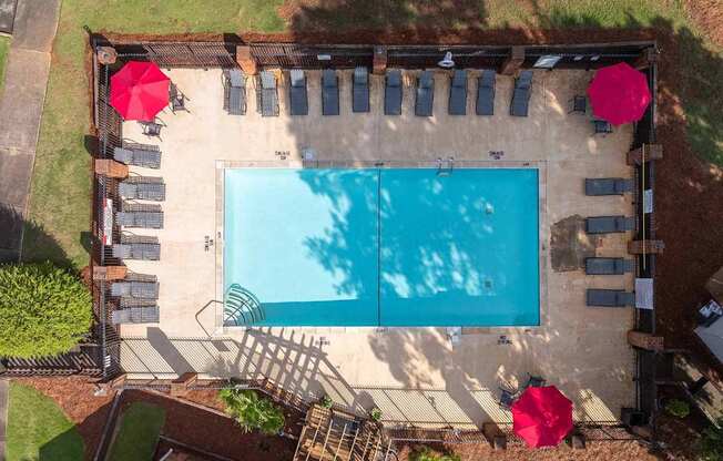An aerial view of a pool surrounded by lounge chairs and umbrellas.