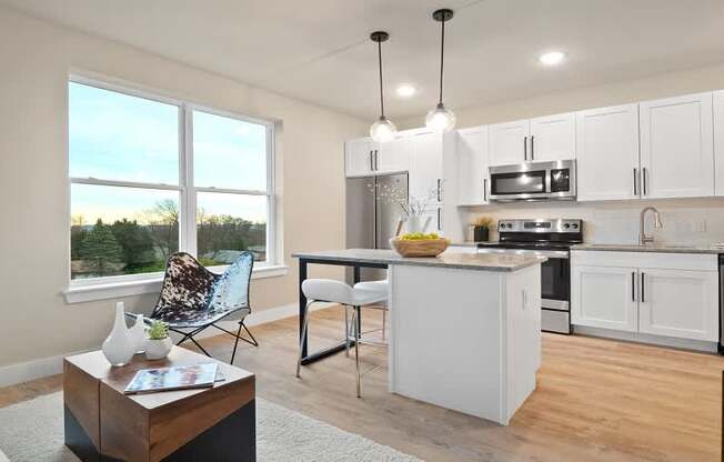 A modern kitchen with white cabinets and stainless steel appliances.