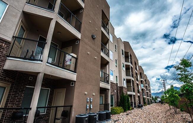 A row of apartment buildings with balconies and black railings.